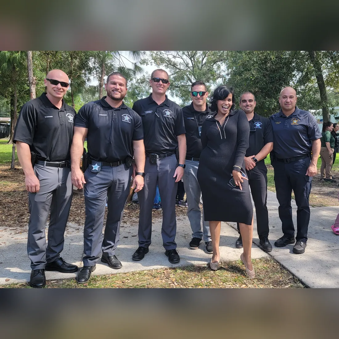 A TBAH team member stands with a group of local law enforcement officers outdoors