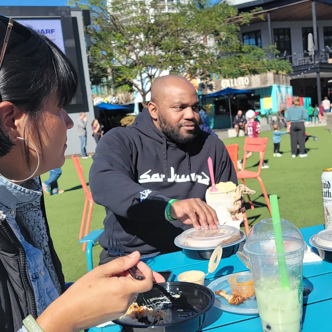 Staff and community members share a meal at an outdoor outreach event
